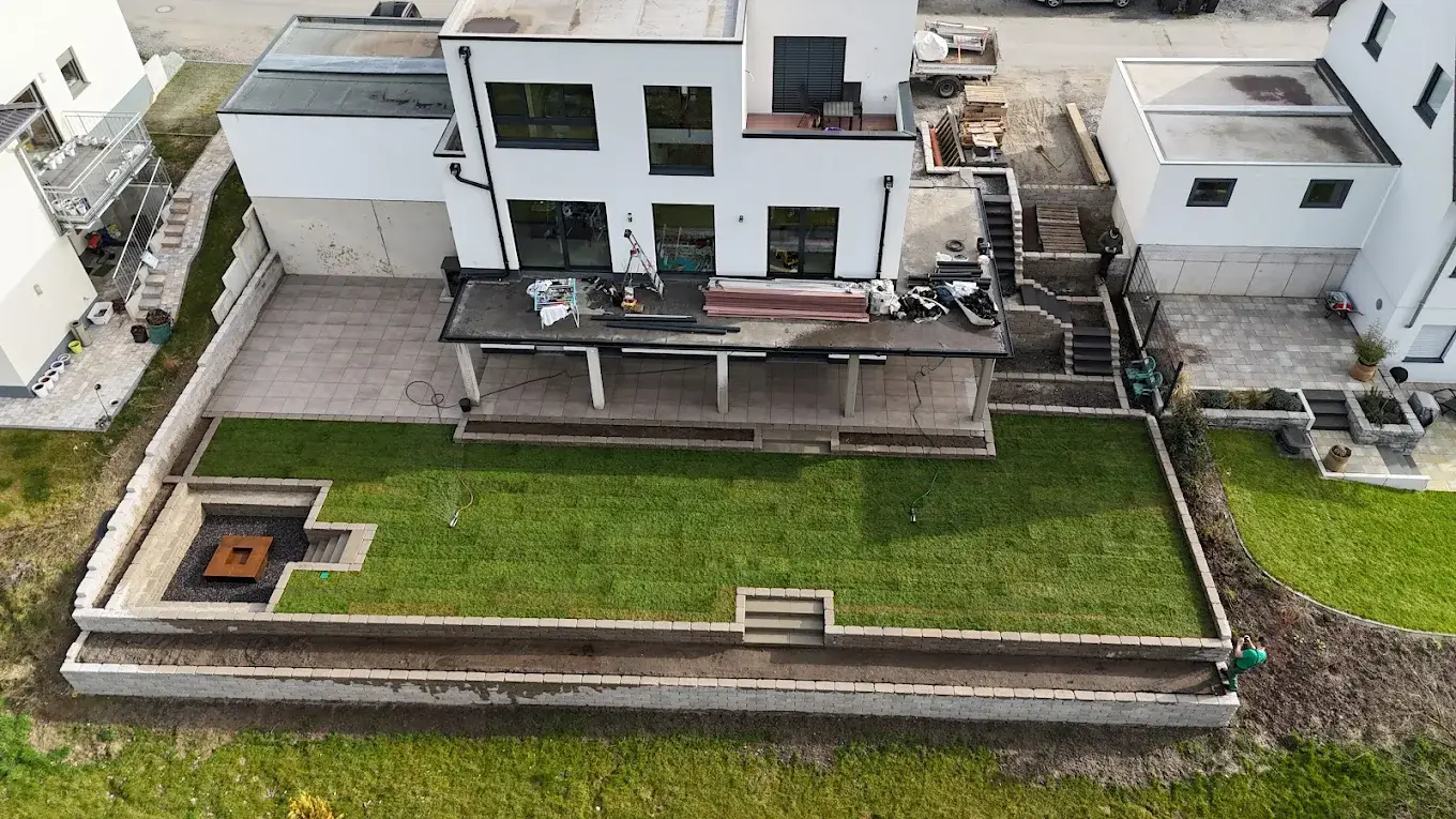 Blick über einen frisch angelegten Garten mit Rasen und Beeten