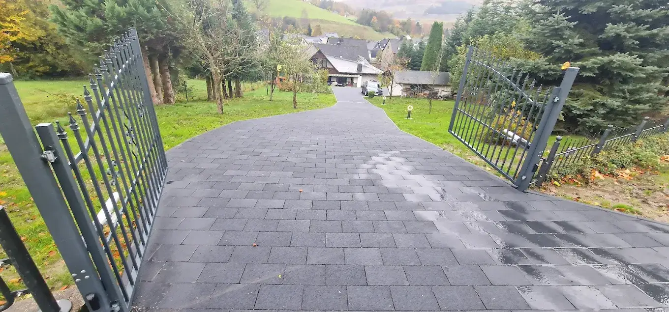 Anthrazitzaun entlang einer Einfahrt am Haus