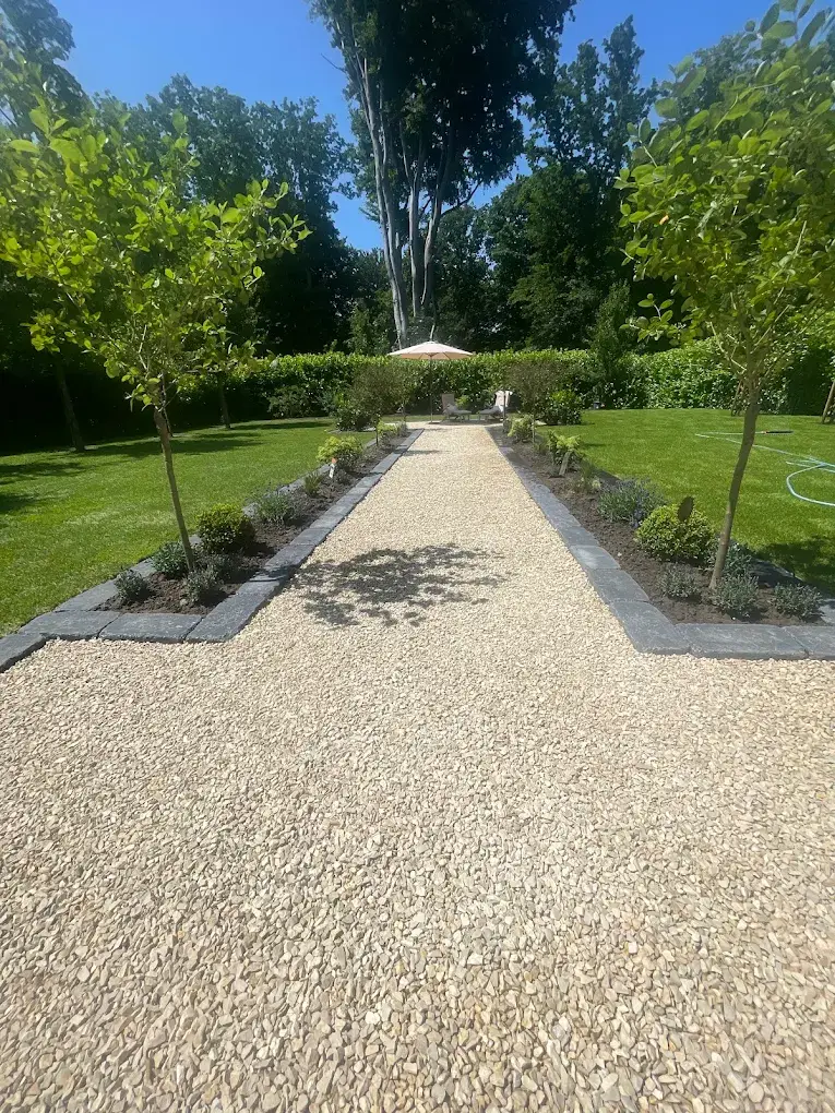 Natürlicher Kiesweg durch einen gepflegten Garten