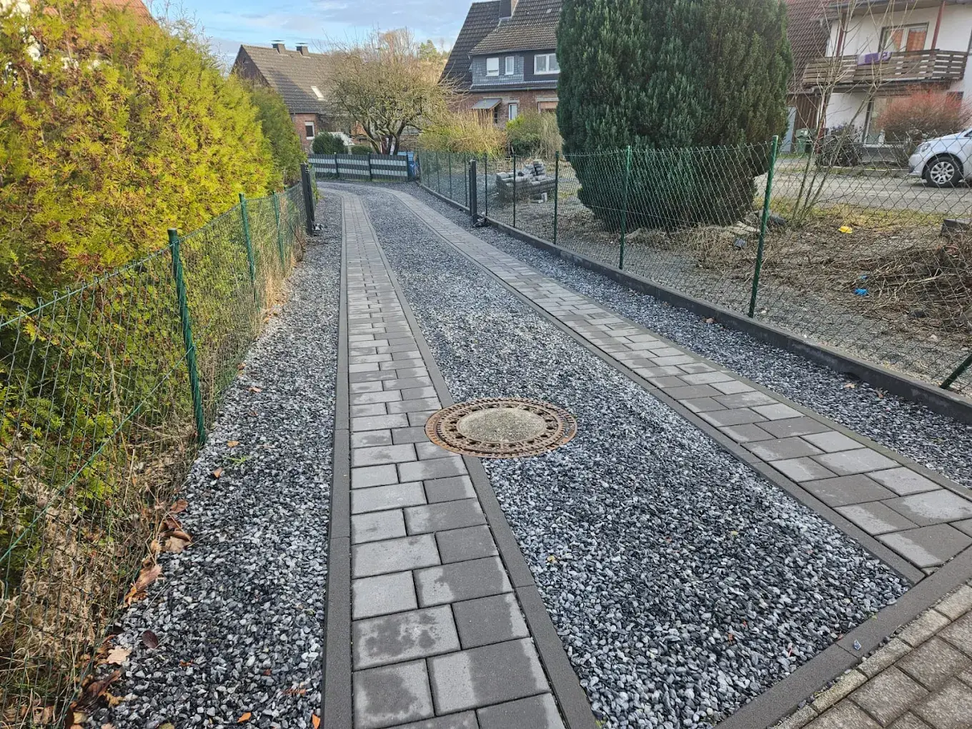 Natursteinpflaster-Weg durch einen herbstlichen Garten