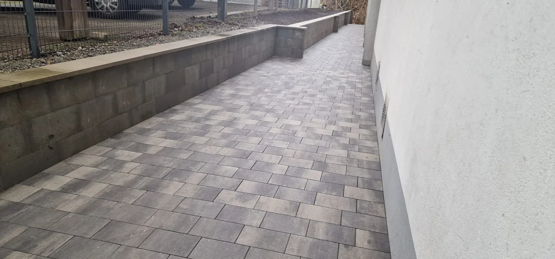 Nachher: Nachher: gepflasterter Weg mit neuer Mauer am Haus
