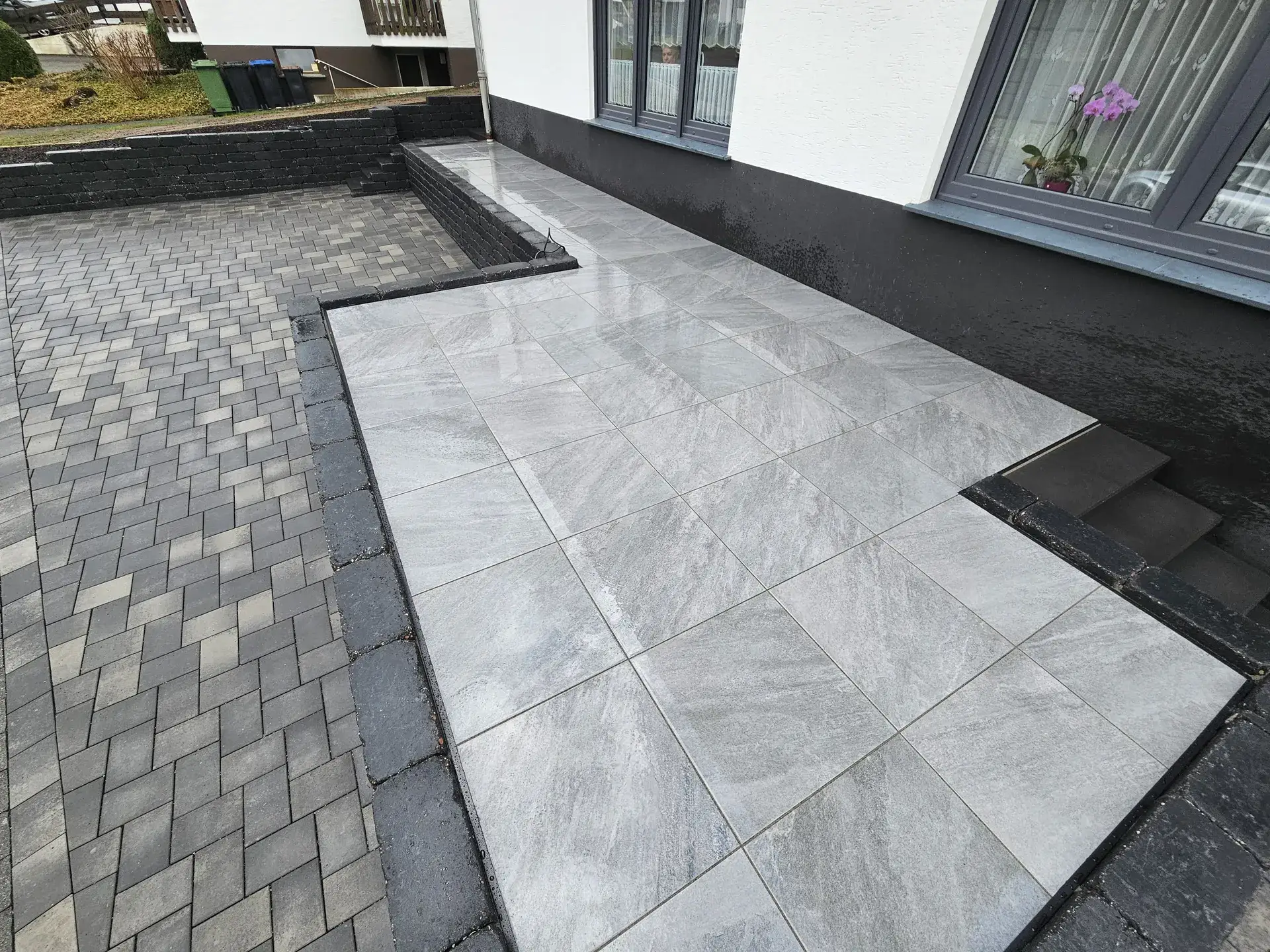 Helle Terrassenplatten kombiniert mit dunklem Pflaster