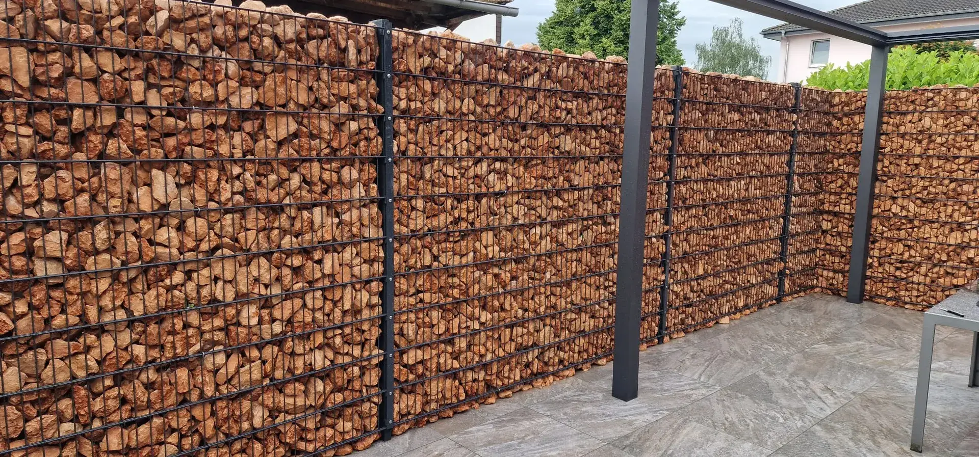 Gabionenwand mit Pergolapfosten auf der Terrasse