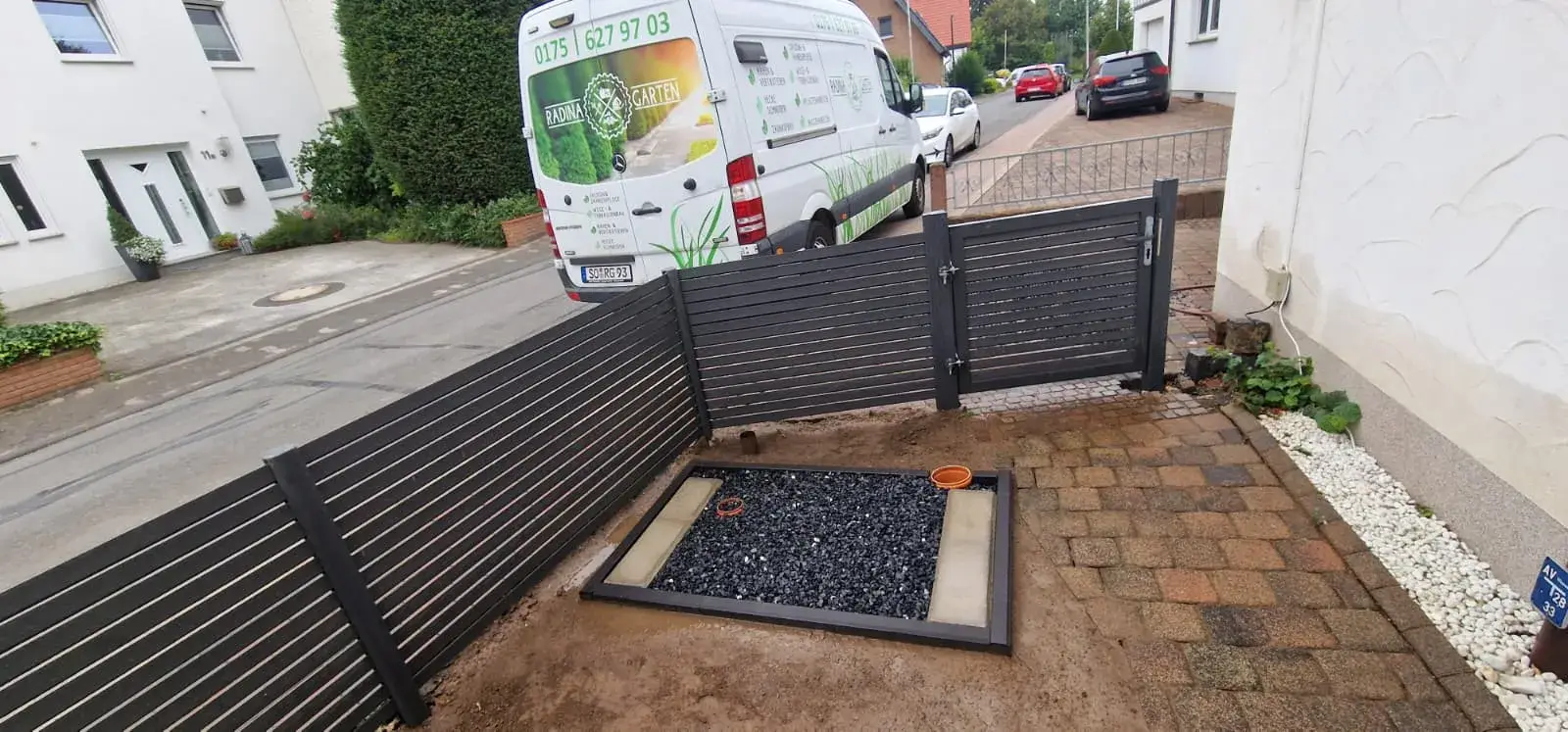 Modernes Tor mit Querlatten-Sichtschutz am Eingang