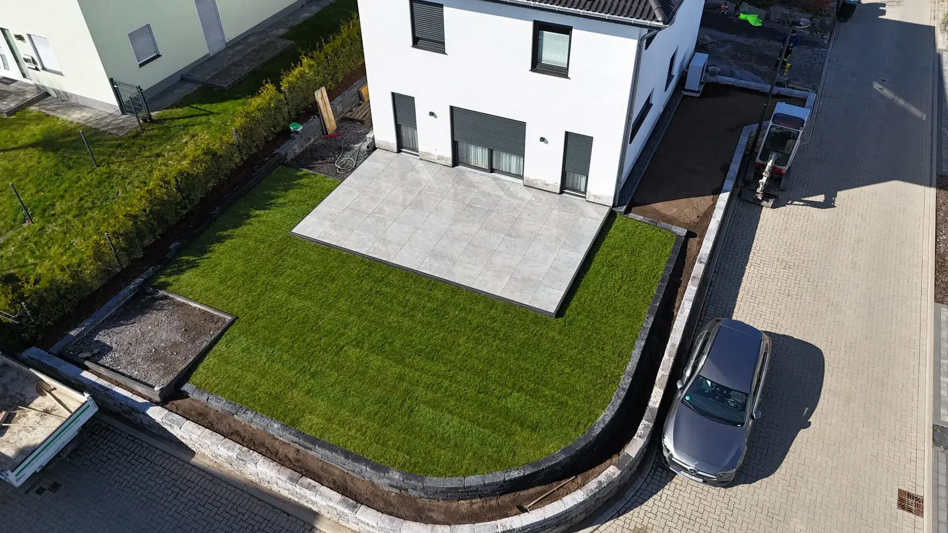Luftbild: frisch verlegter Rollrasen mit Terrasse am Neubau