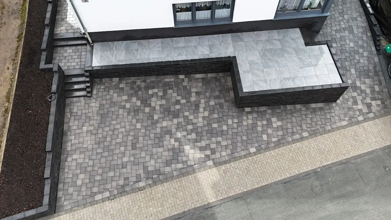 Gepflasterte Terrasse mit Sitzmauer und Kiesbeet
